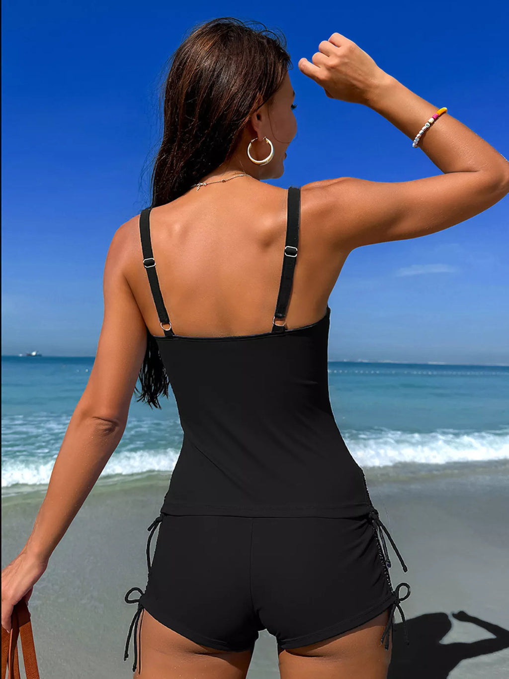 Back view of black drawstring tankini set with thin straps and pink floral accents