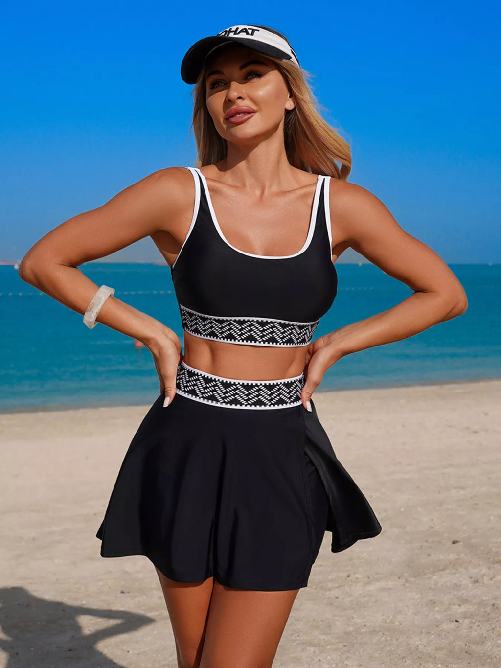 Black tank and skort swimsuit with patterned waistband and flared skirt silhouette