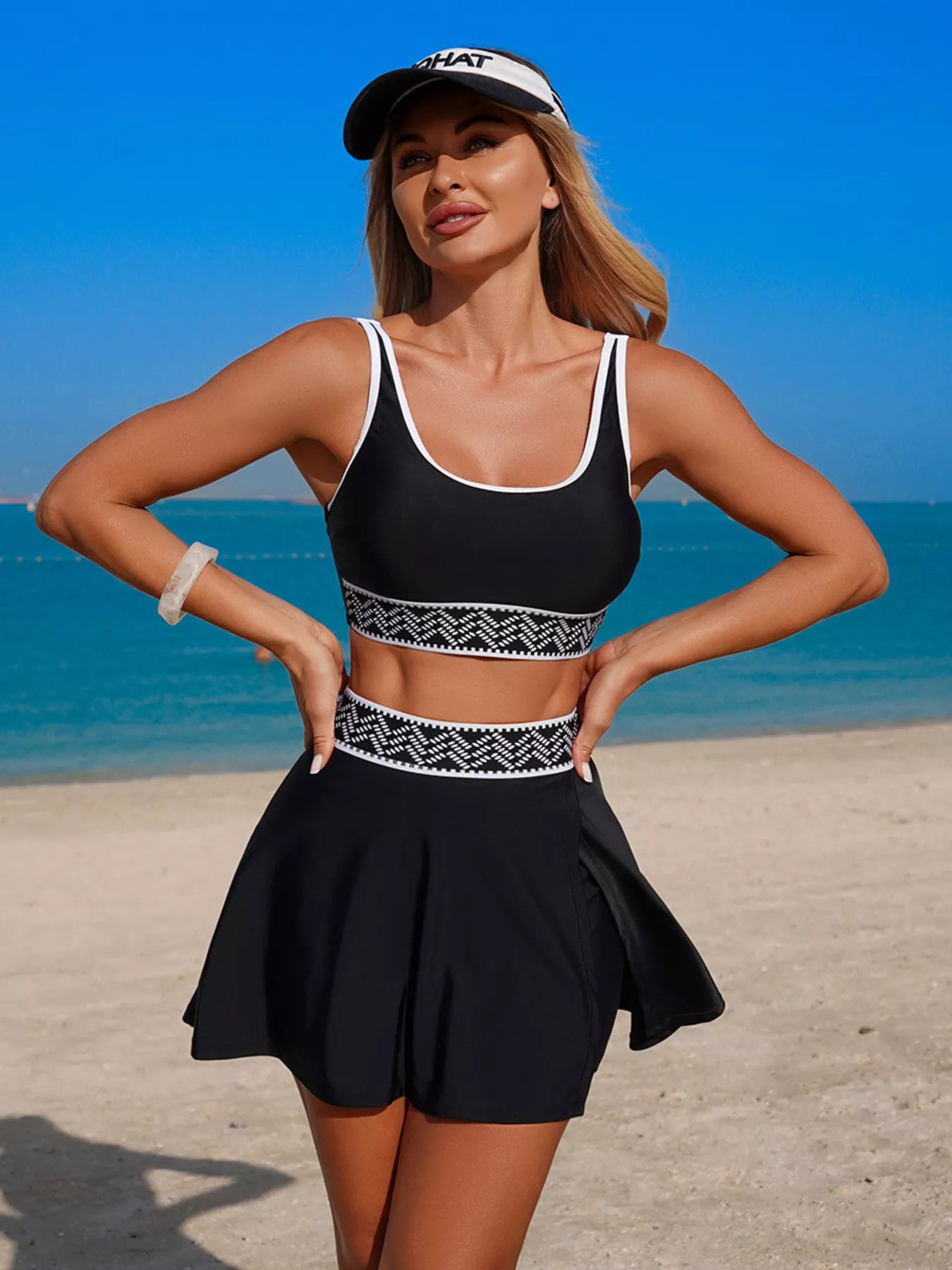 Black tank and skort swimsuit with patterned waistband and flared skirt silhouette