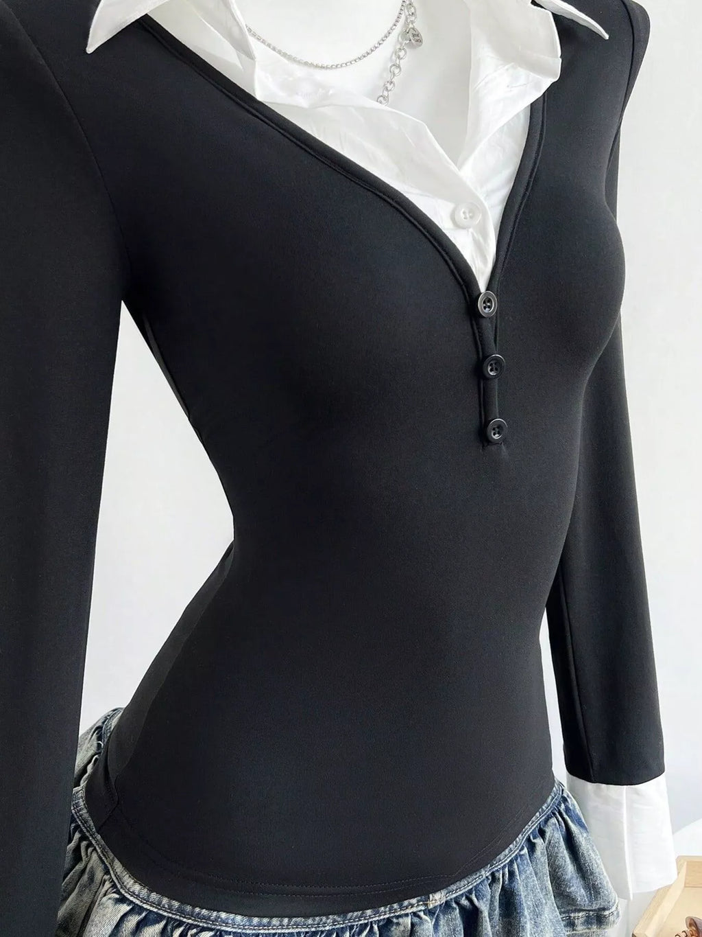 Black long-sleeve polo shirt front, button placket and pointed white collar