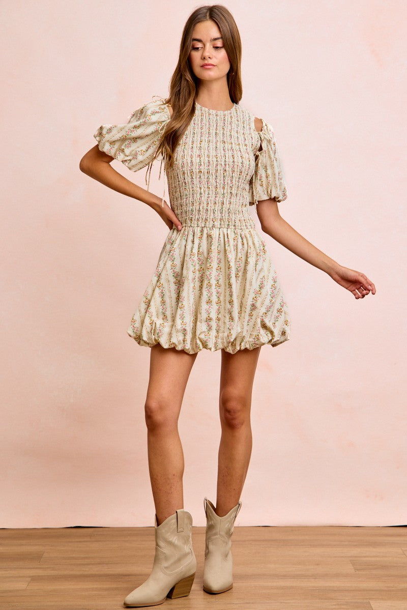 Ivory floral dress with smocked bodice, puff sleeves, and tiered skirt with ruffle hem