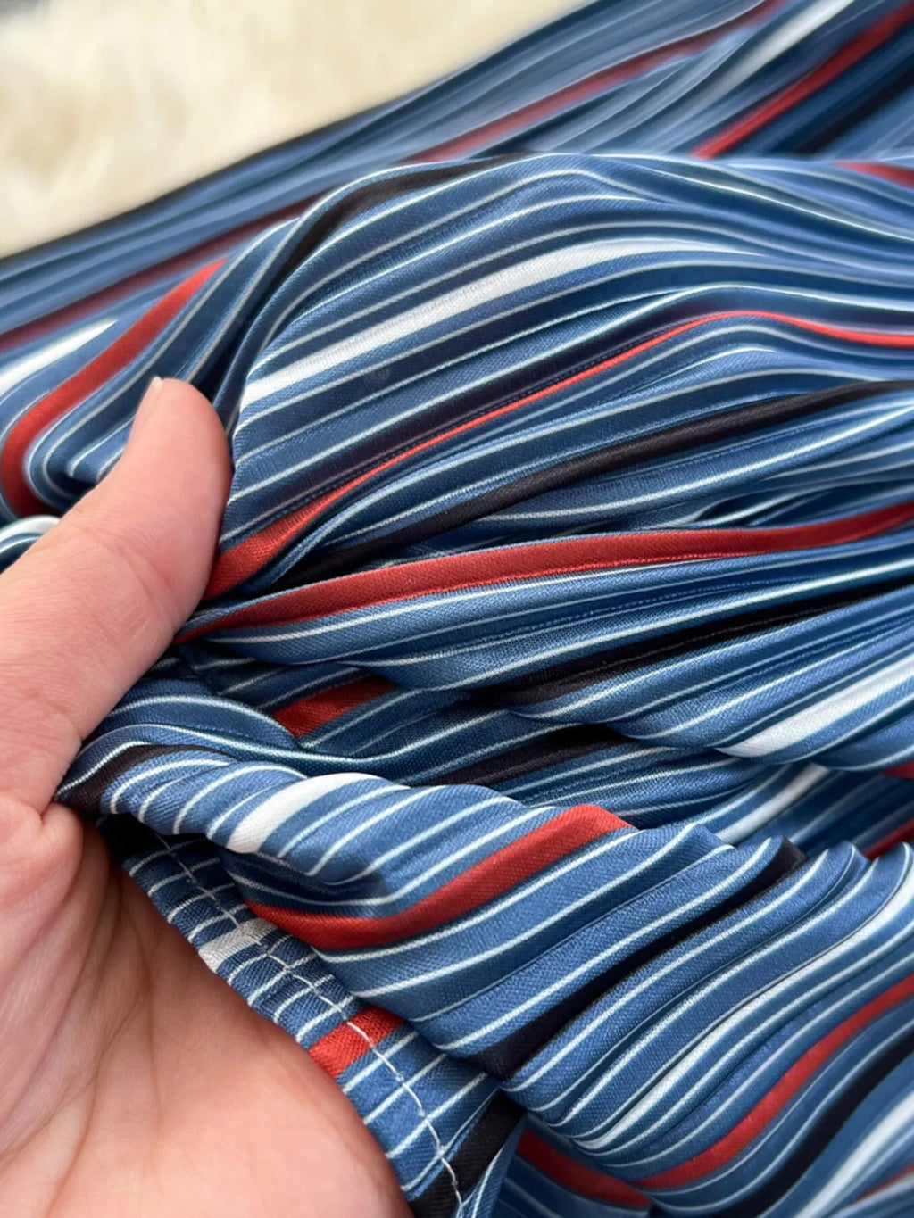 Blue striped denim patchwork skirt fabric detail with red and white stripes
