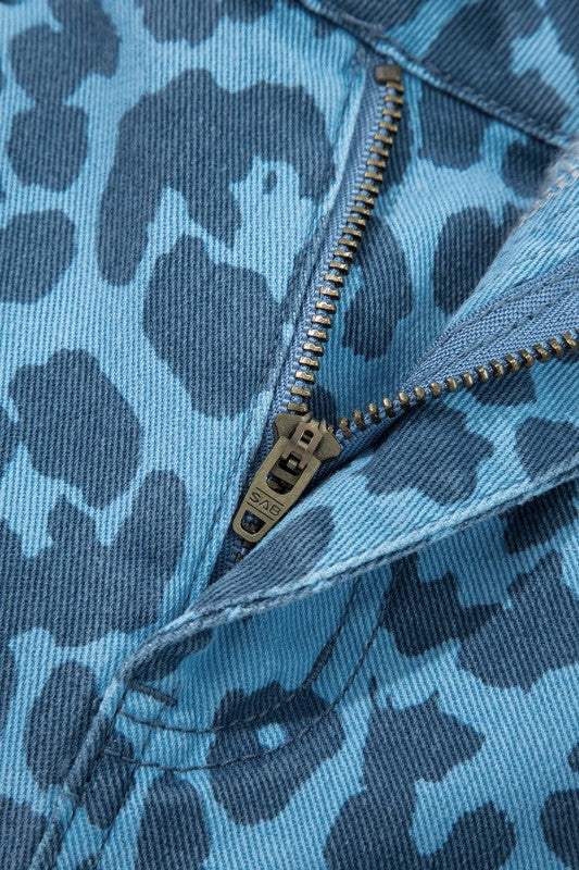 Close-up of leopard denim jeans: gold zipper and front seam detail