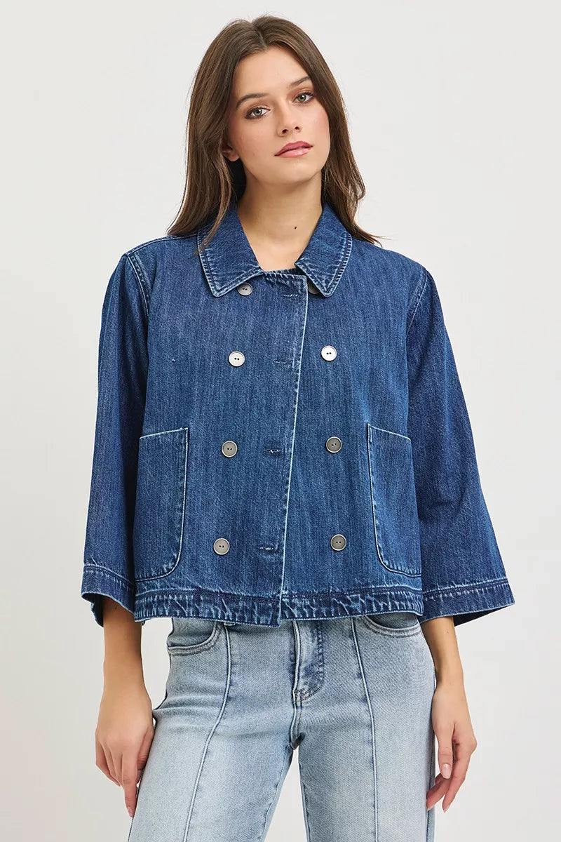 Dark blue cropped denim jacket with pointed collar and two chest flap pockets, button-up
