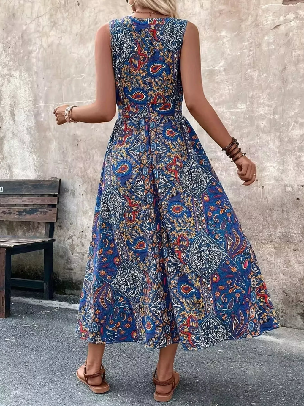Back view: blue paisley sleeveless romper with gathered waist and high neckline