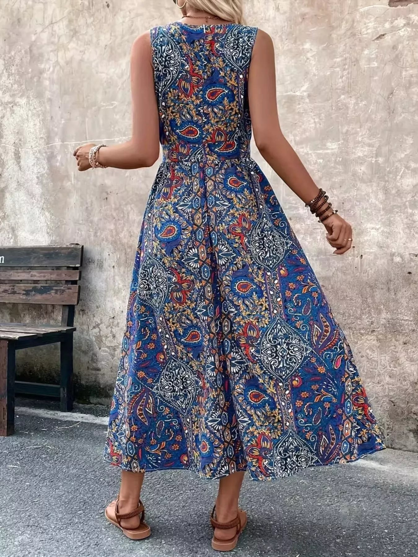 Back view: blue paisley sleeveless romper with gathered waist and high neckline