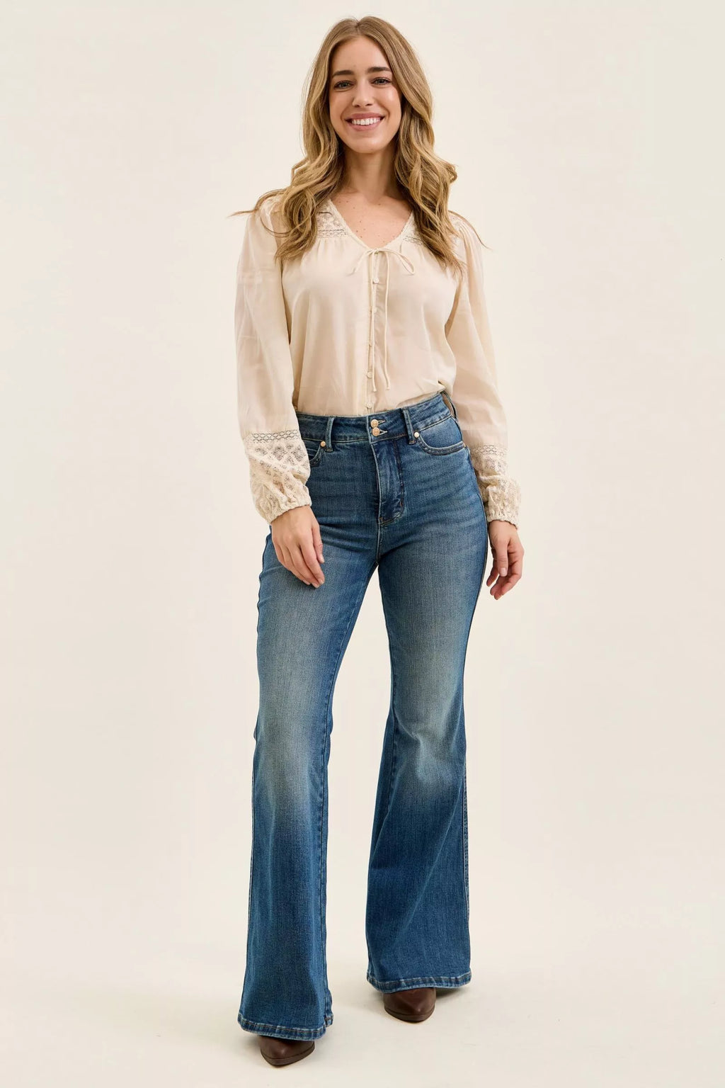 Dark denim high-waist flare jeans, front view with two-button waistband and pockets