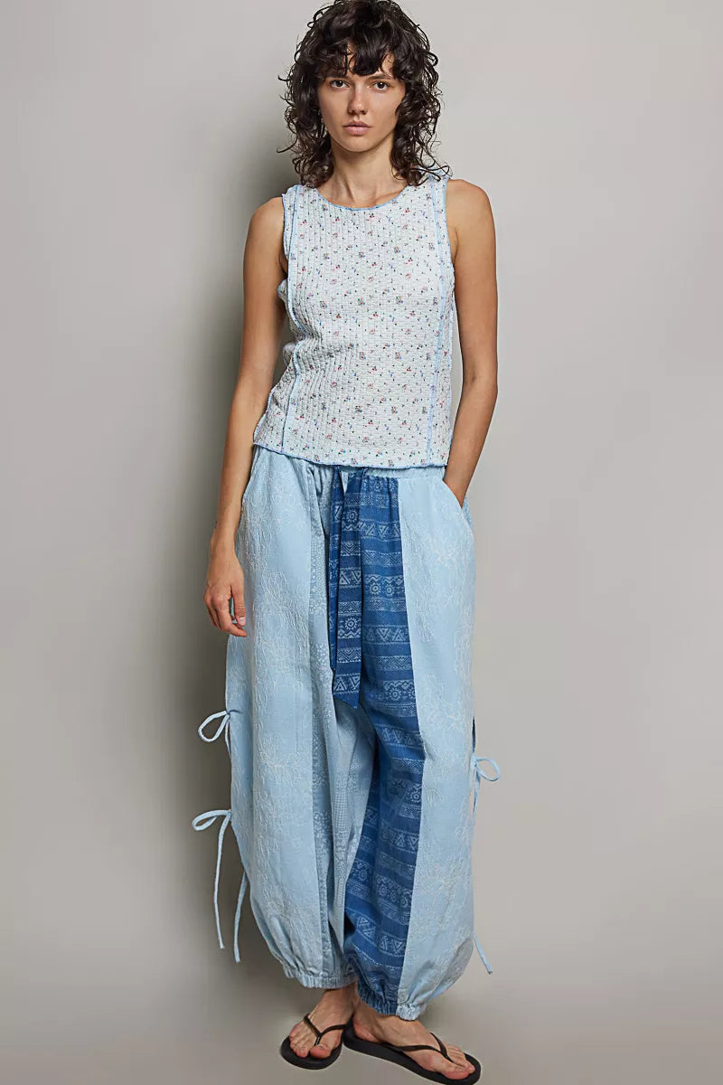 Light blue sleeveless tank with round neck; micro-floral print and gathered waist seam