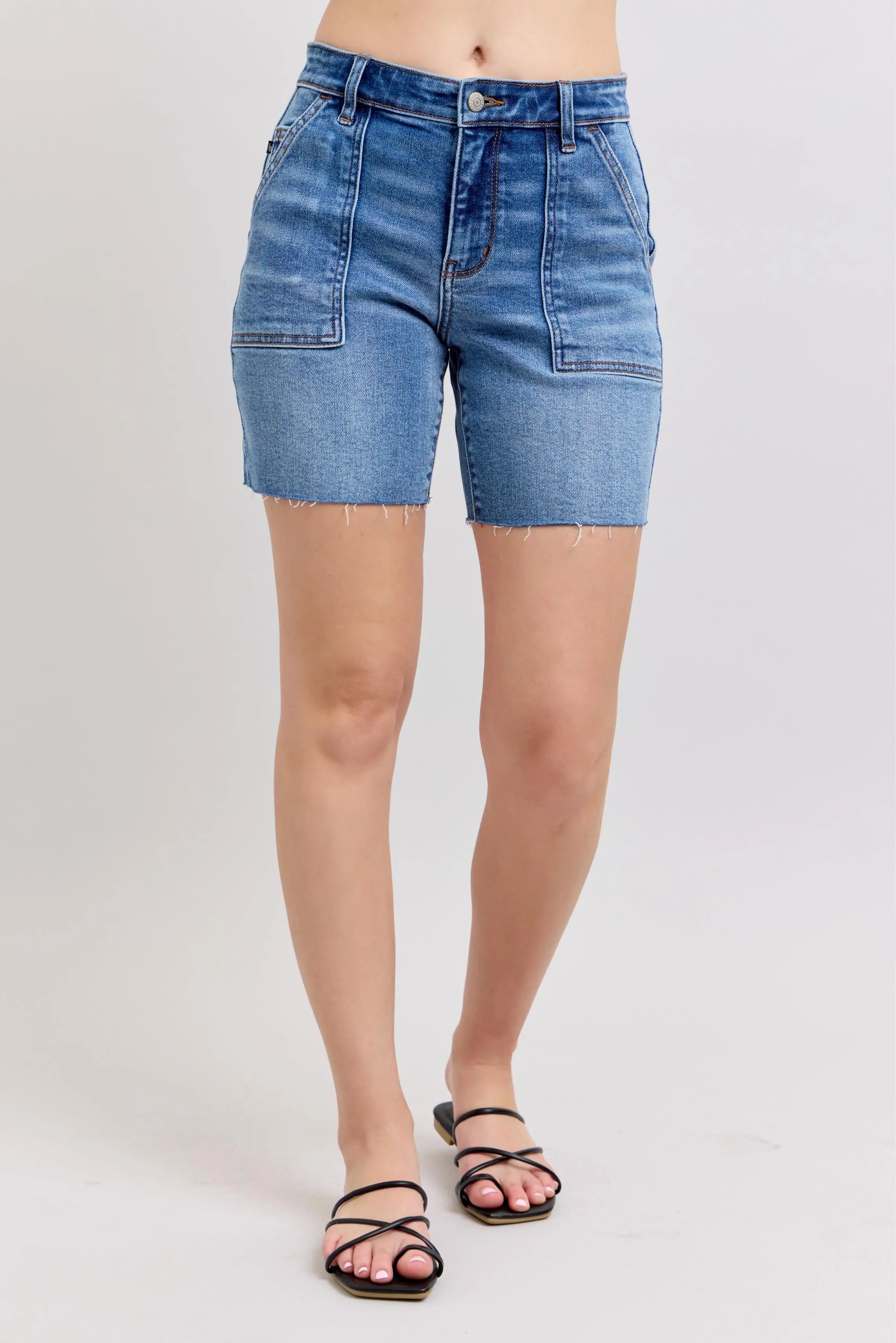 Plus-size mid-rise denim bermuda shorts in light blue wash, cuffed hem, flap pockets