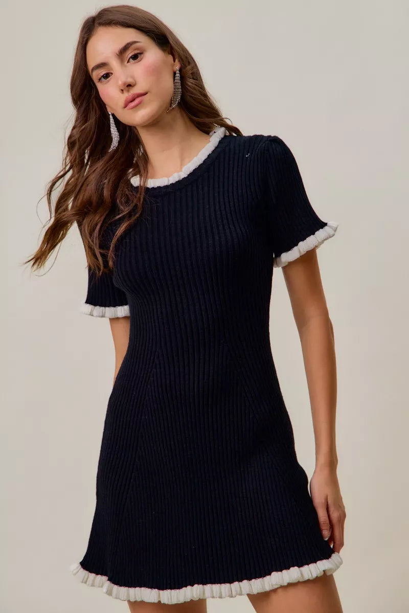 Black knit mini dress with white ruffle-trim edges, short sleeves and ribbed knit