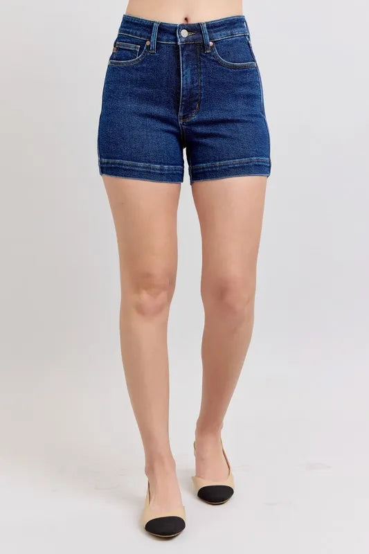 Dark blue high-waist denim shorts, front view with front pockets and button closure
