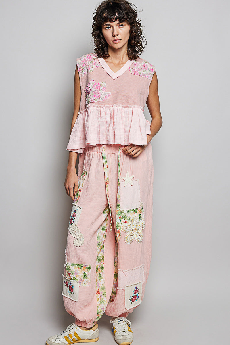Powder pink sleeveless peplum top with floral shoulder patches and tiered ruffles