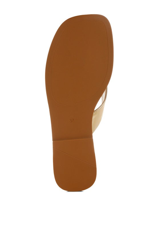 Gold metallic thong sandal outsole, smooth sole underside view