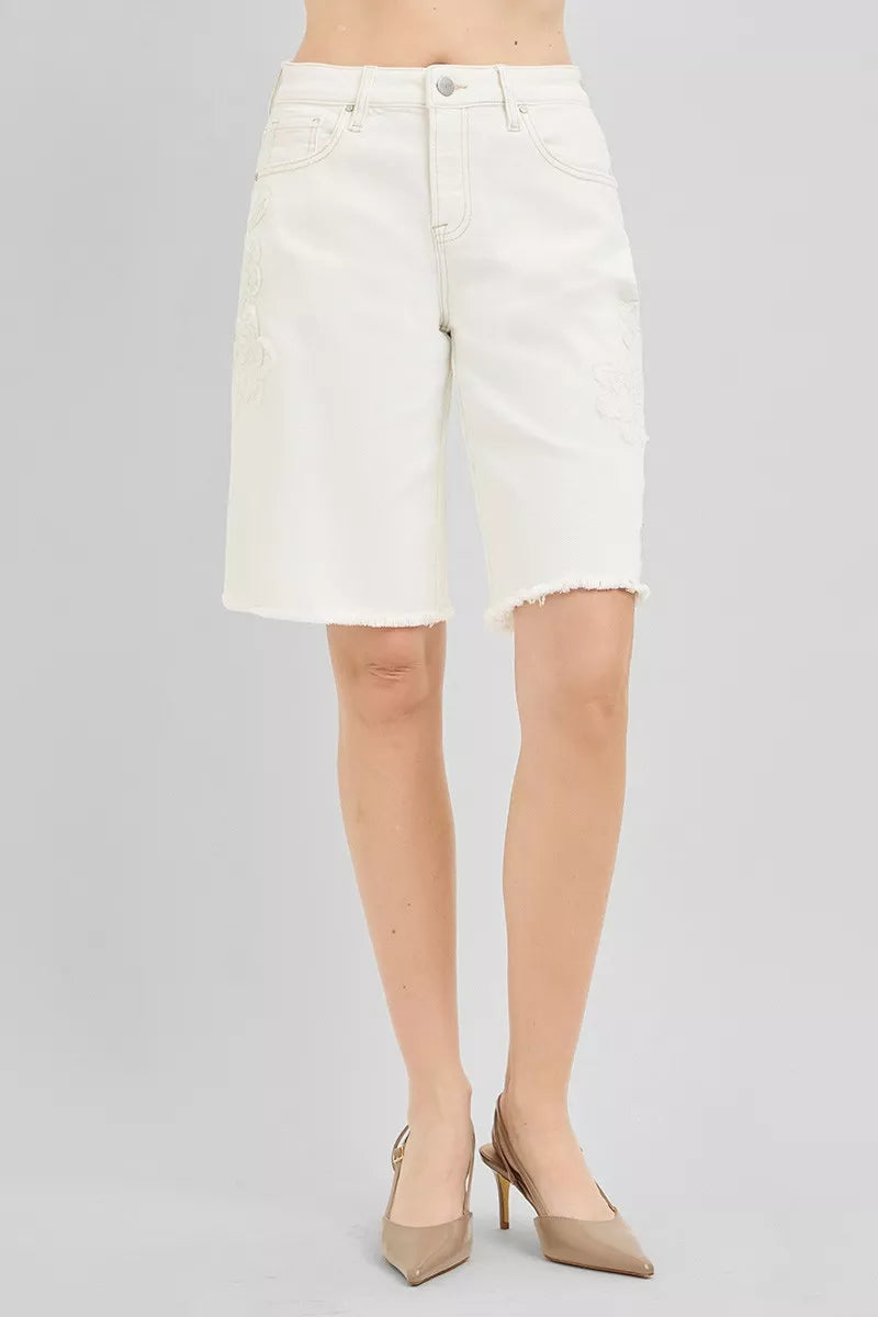 Cream denim bermuda shorts with floral detailing on the legs and frayed hem