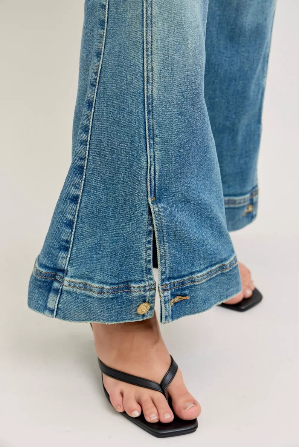 Flare-hem detail with side seam slit on vintage-wash blue jeans