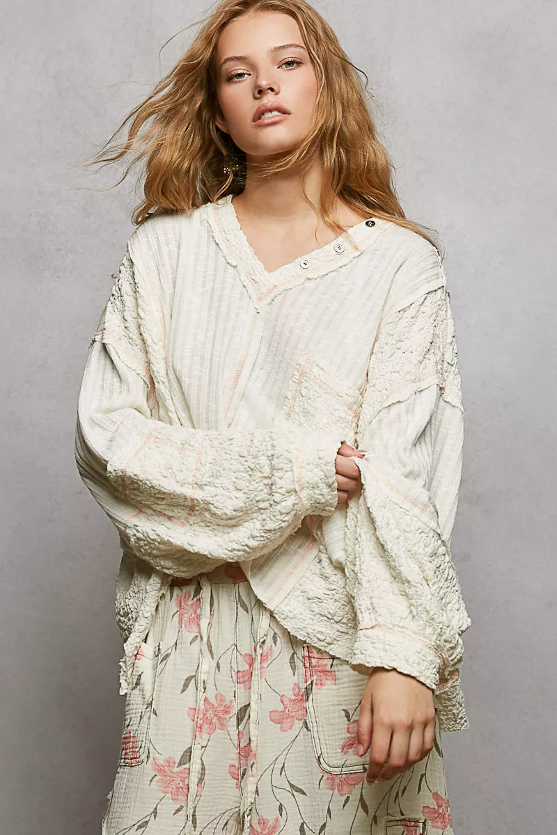 Off-white V-neck long-sleeve top with stitch accents