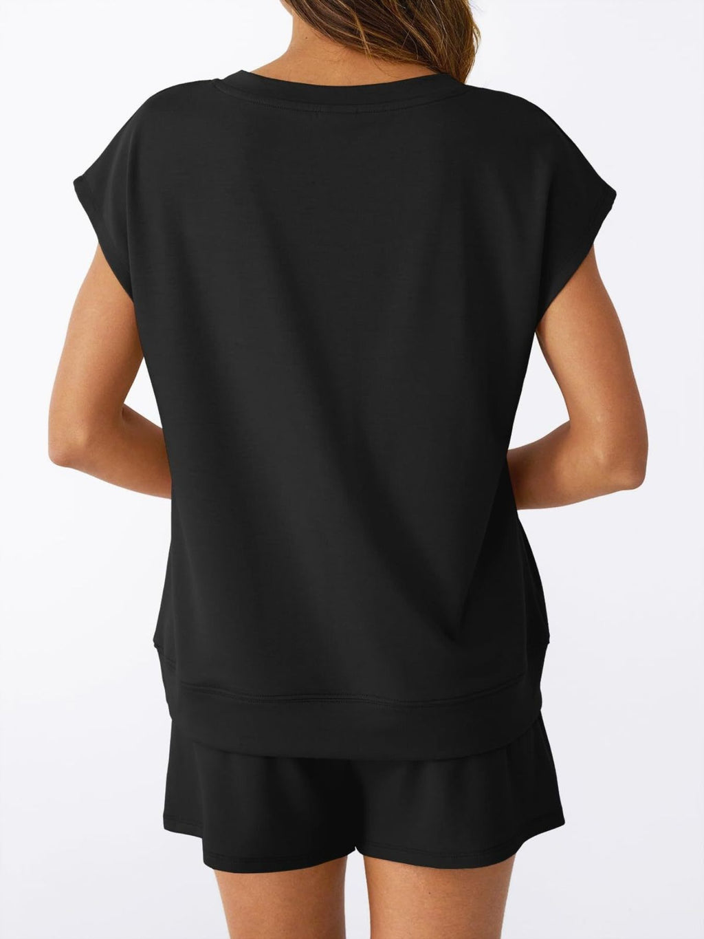 Vista trasera del conjunto negro: camiseta y shorts con dobladillo elástico