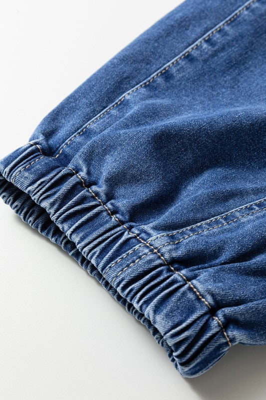 Ruched denim cuff with elastic at hem and visible seam stitching, close-up