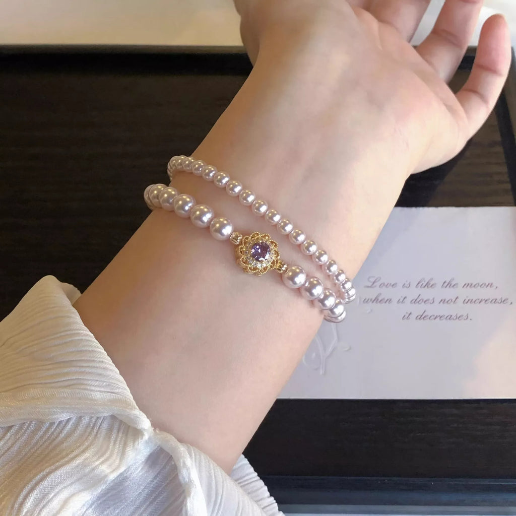 18K Gold-Plated Pearl Bracelet featuring stacked freshwater pearls and a gold round floral charm