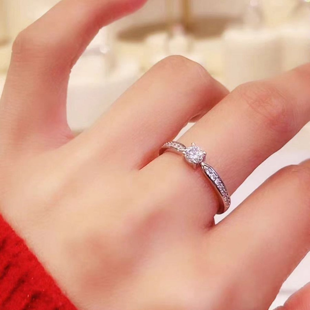 Silberner Ring mit rundem Moissanit in Krappenfassung und Pavé an den Seiten