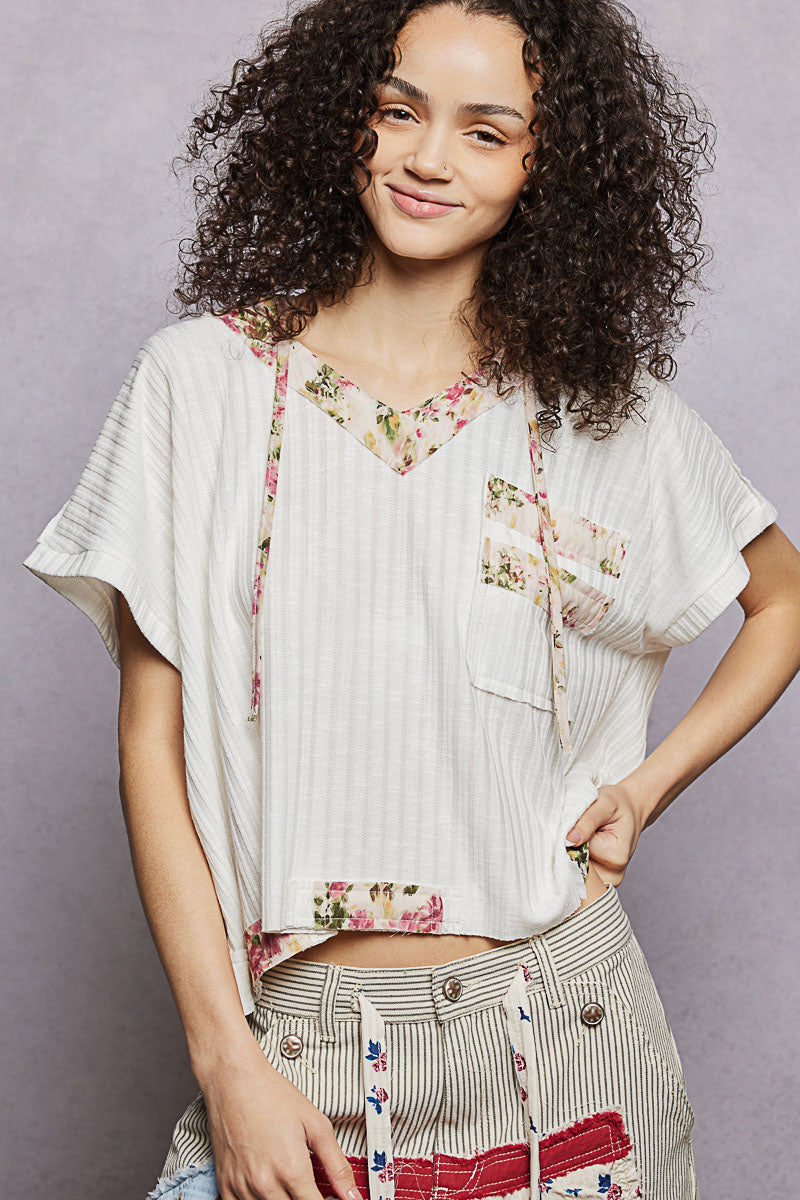 Off-white short-sleeve hooded top with floral trim and chest pocket detail