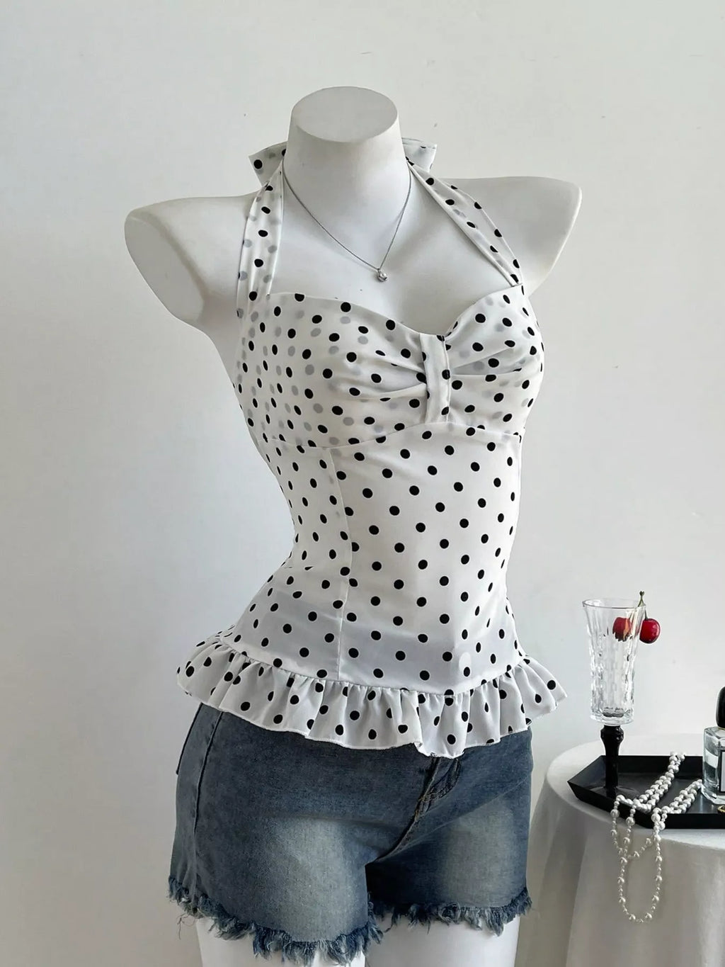 Polka dot halter neck cami with ruffled peplum hem and sweetheart neckline, black dots