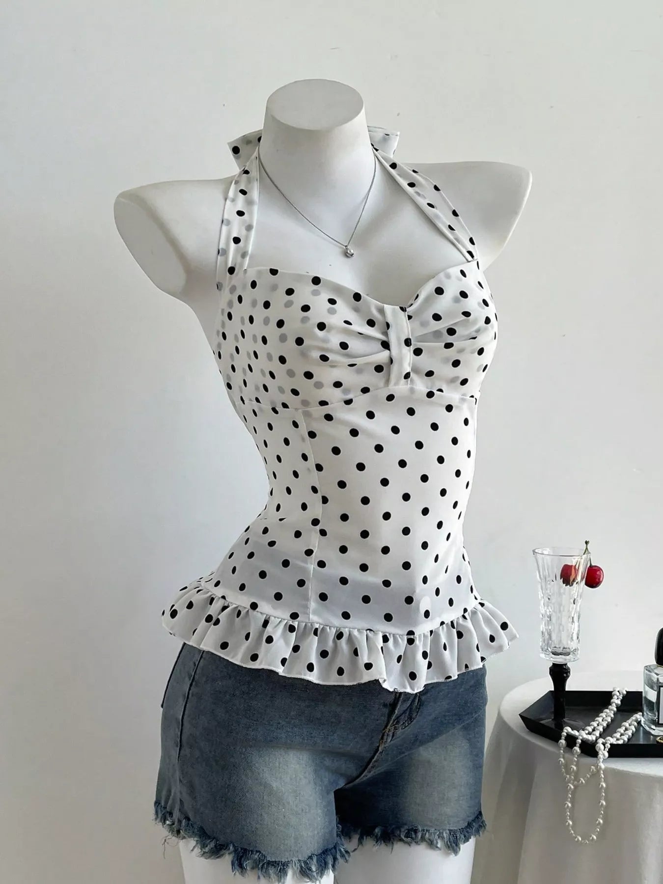 Polka dot halter neck cami with ruffled peplum hem and sweetheart neckline, black dots