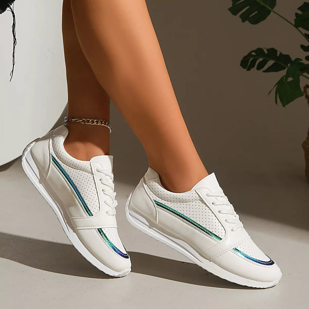 Weiße Schnürsneaker schräg seitlich, Perforierungen und grün-blauer Seitenstreifen