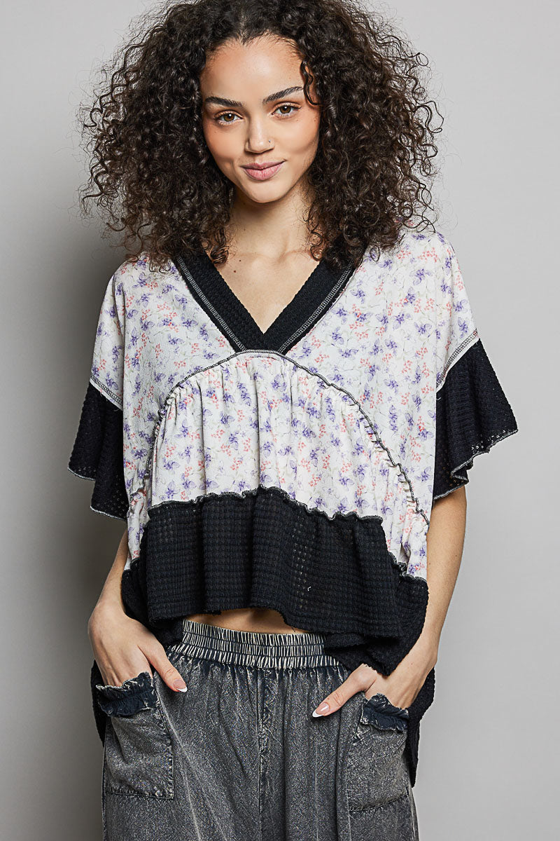 Floral V-neck blouse with black yoke trim and gathered ruffle tiers