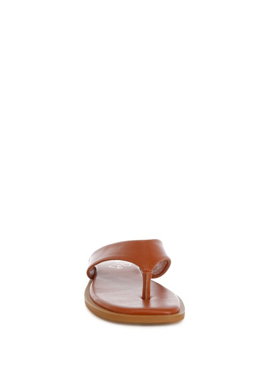 Tan toe-post thong flats with single toe strap and flat cushioned sole