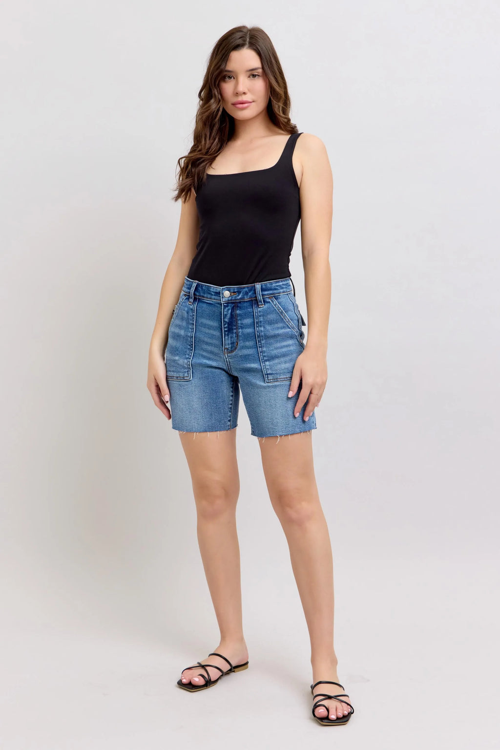 Plus-size mid-rise denim bermuda shorts with back flap pockets, light blue wash, frayed hem