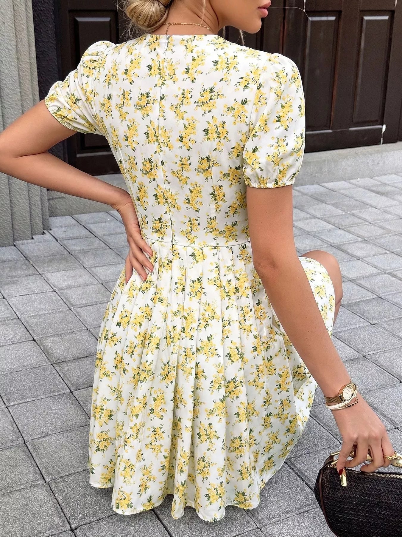 Yellow floral mini dress, back view with puff sleeves and gathered waist detail