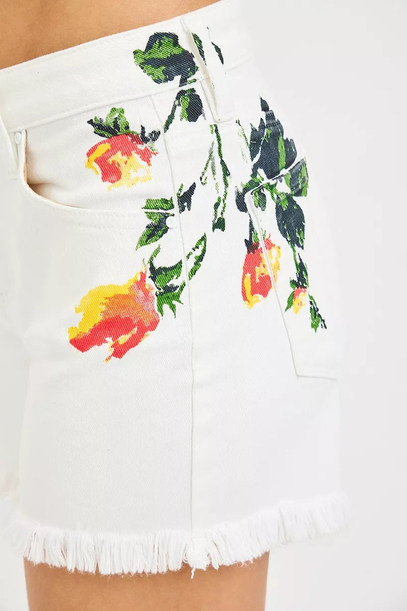 Close-up of white shorts with green leaves and yellow-red flower print