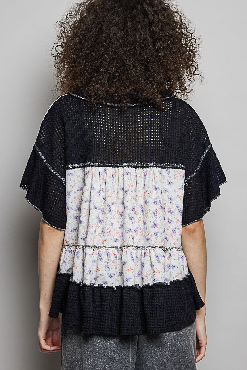 Back view: floral-and-black tiered V-neck woven blouse with gathered waist