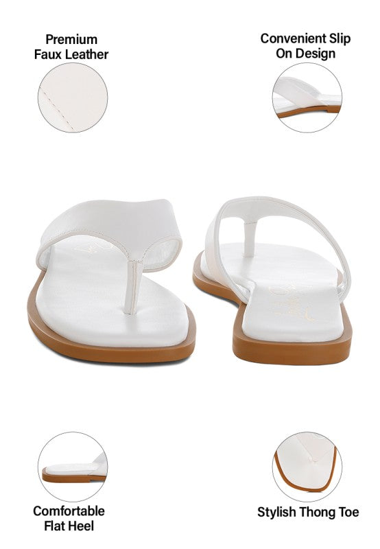 White toe-post thong flats with flat sole and toe-separating strap.
