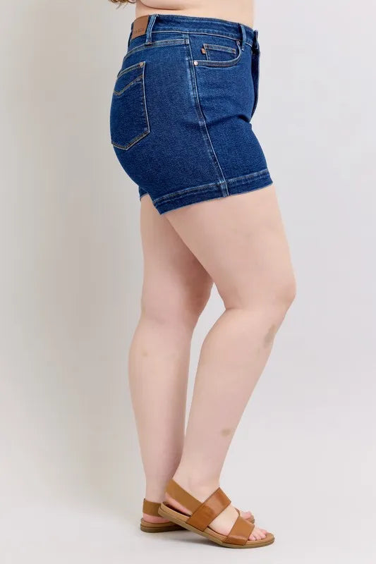 Dark blue denim shorts, back/side view with front pocket and seam details