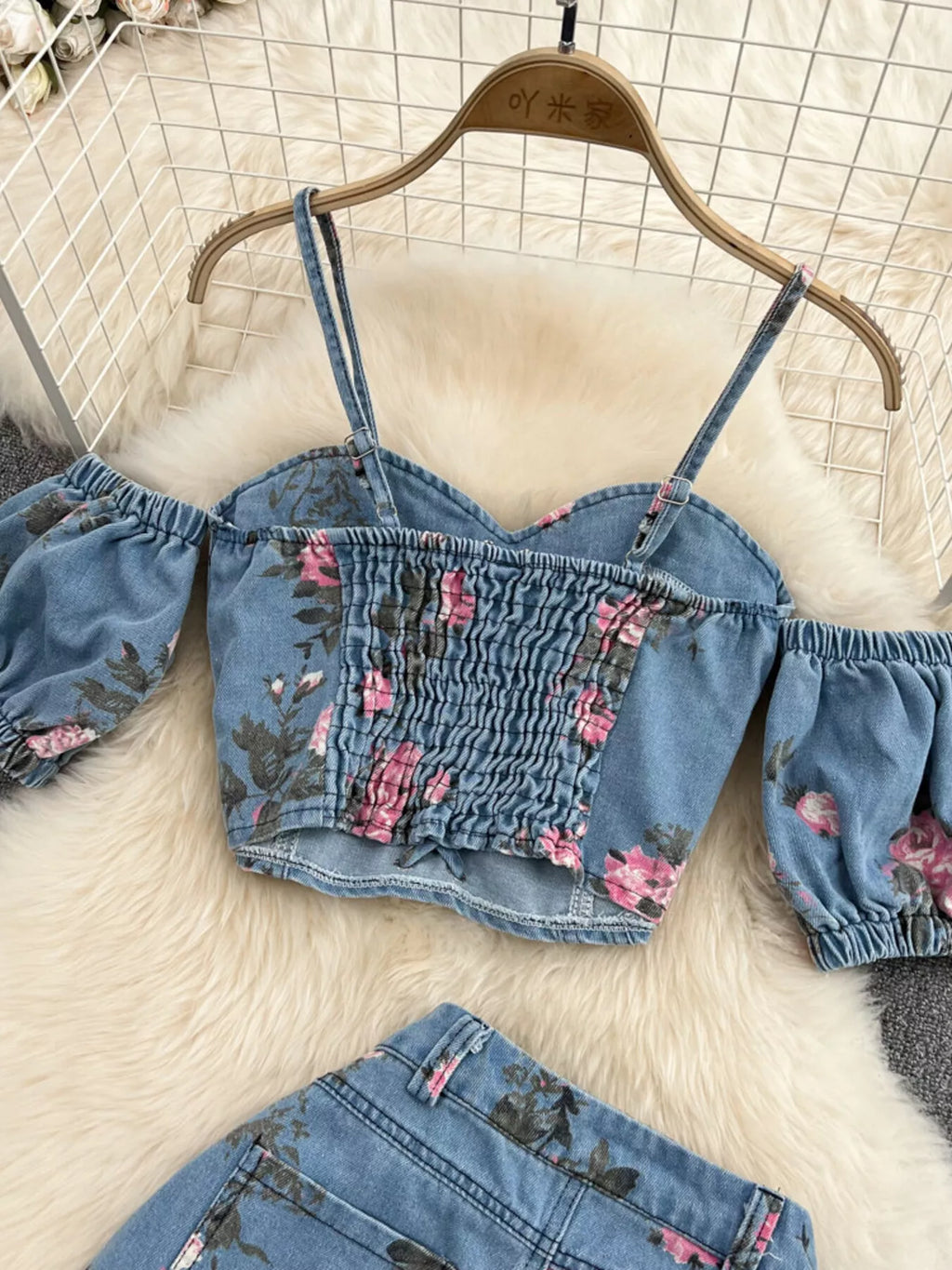 Blue denim cami top with floral smocking at neckline and off-shoulder puff sleeves
