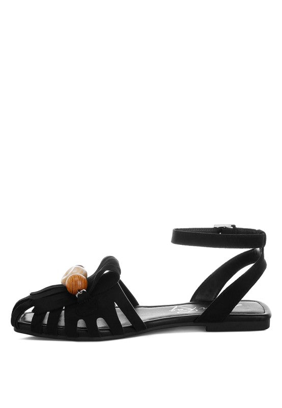 Black cutout flat ankle-strap sandals with front fringe and chunky bead accents