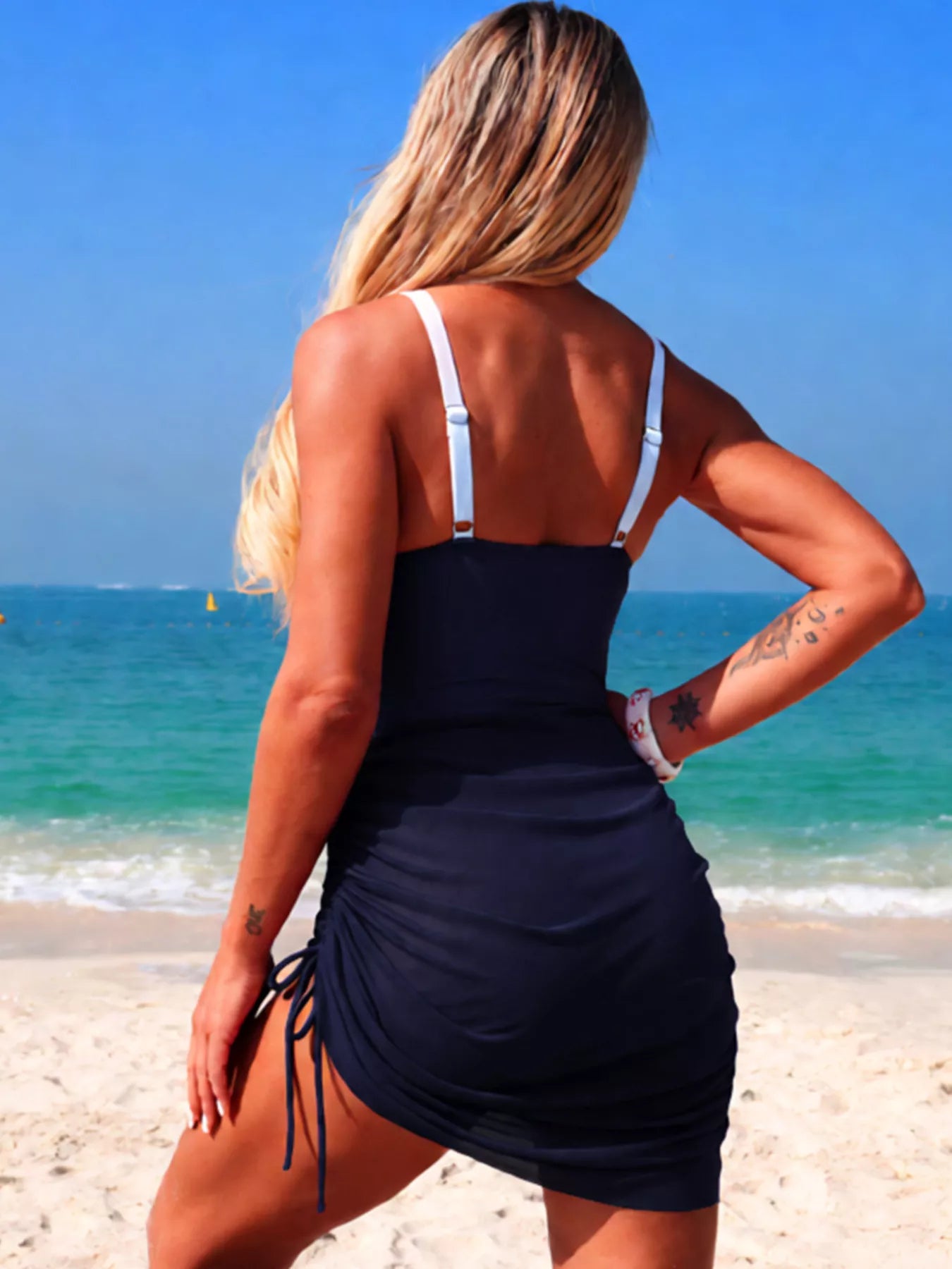 Back view of black color-block cutout one-piece swimsuit with adjustable drawstring side ties