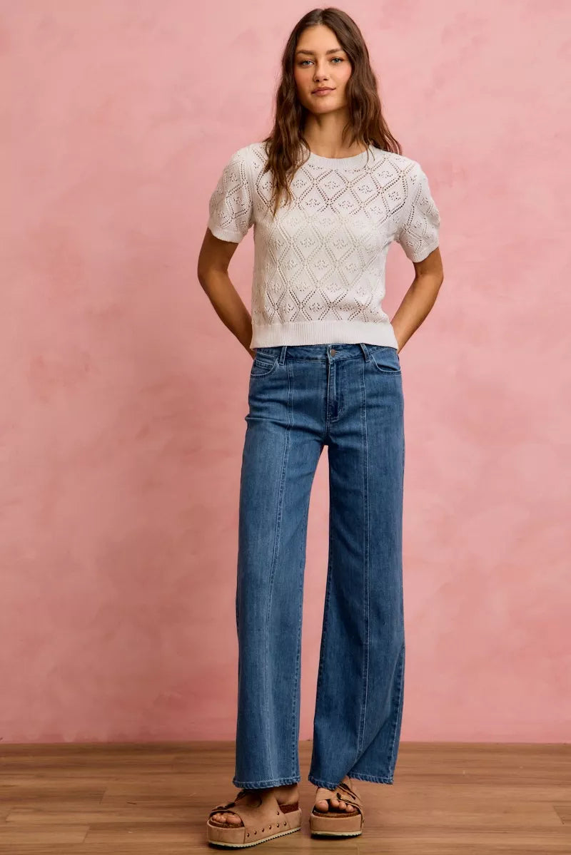 Denim mid-rise stretch jeans, wide-leg cut with seam details and button-and-zip closure.
