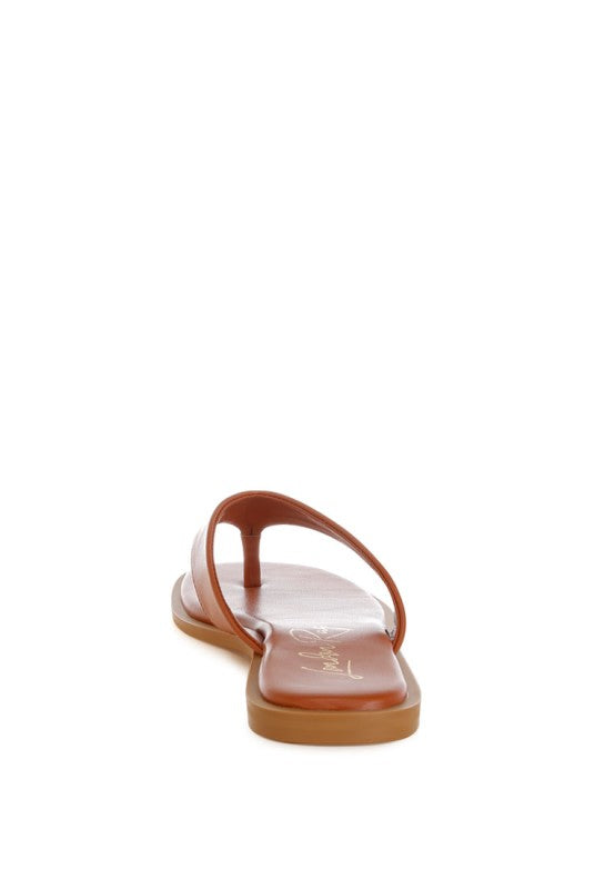 Tan toe-post thong flats, angled view showing thong strap and flat sole profile