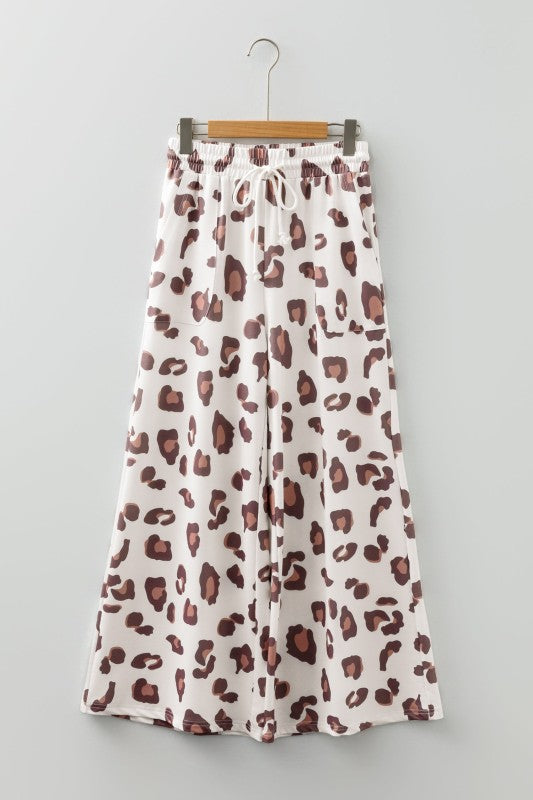 White leopard-print wide-leg pants with drawstring and elastic waist on a hanger