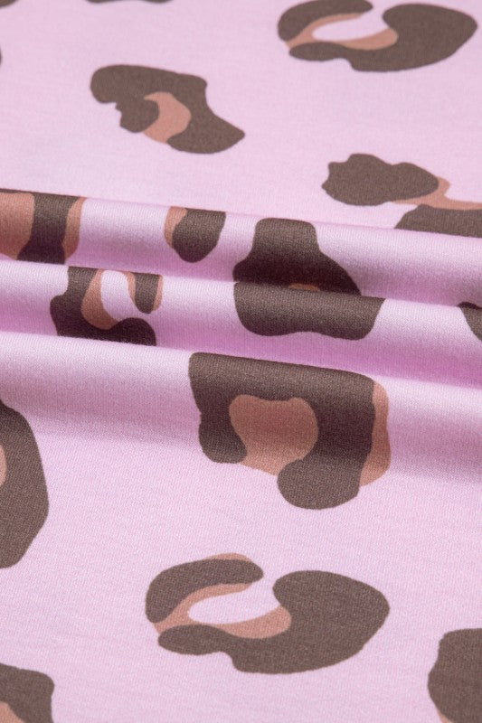 Leopard-print fabric close-up in pink with brown and tan spots