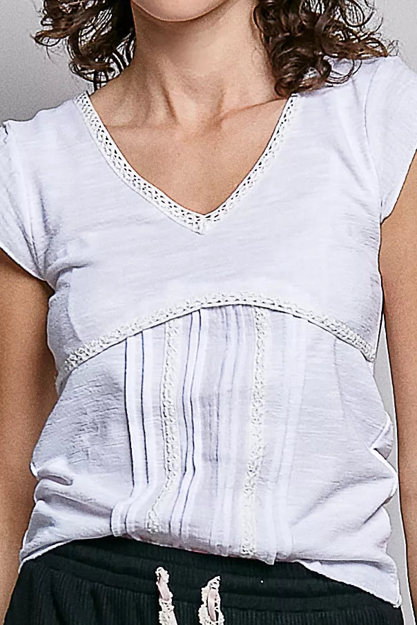 Close-up: off-white V-neck textured knit top with lace neckline trim