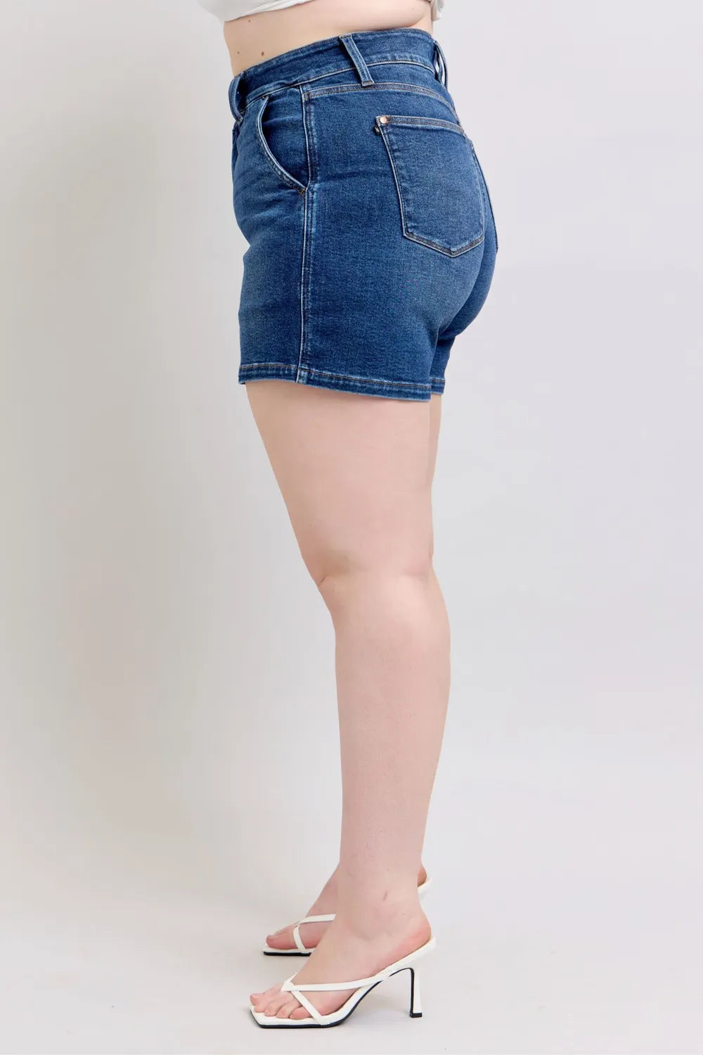 Back side view of dark denim shorts with back pocket and stitched seams