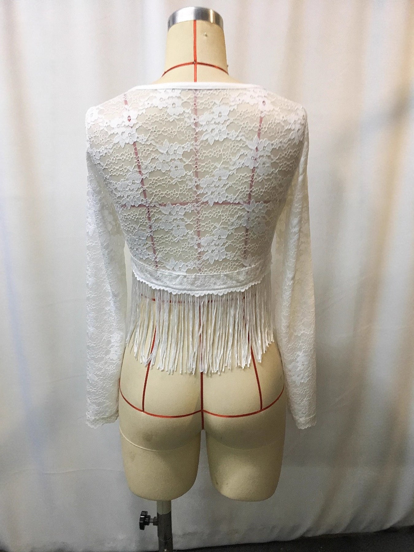 White lace long-sleeve top, back view, with scalloped yoke and fringe hem