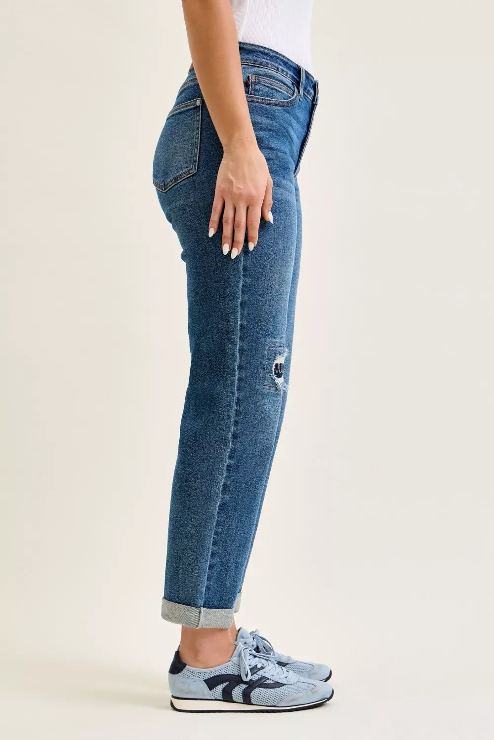 Medium blue mid-rise boyfriend jeans with knee repair detail and cuffed hem