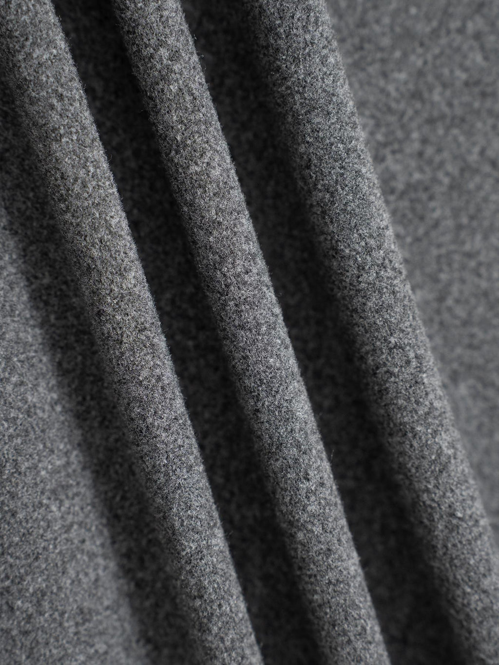 Gray knit fabric texture of relaxed drawstring pants, close-up