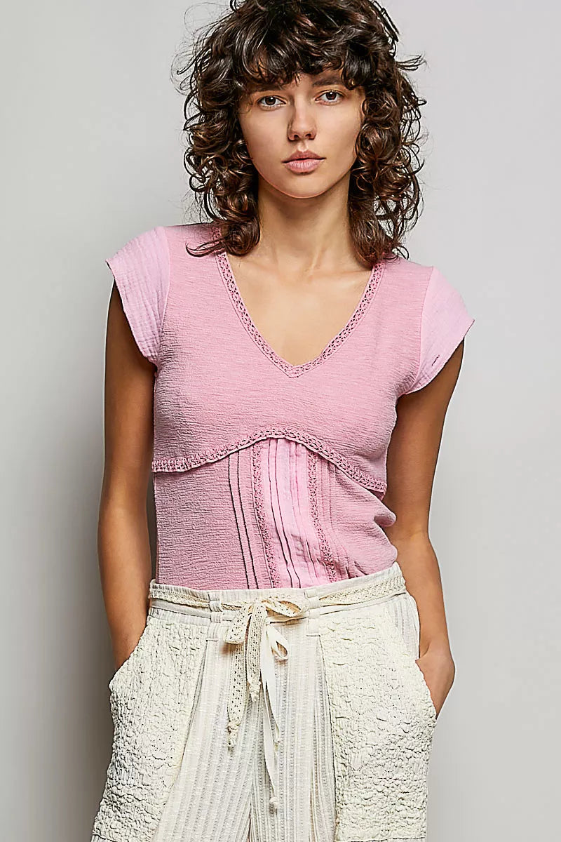 Soft pink V-neck knit top with lace-trimmed neckline and textured bodice