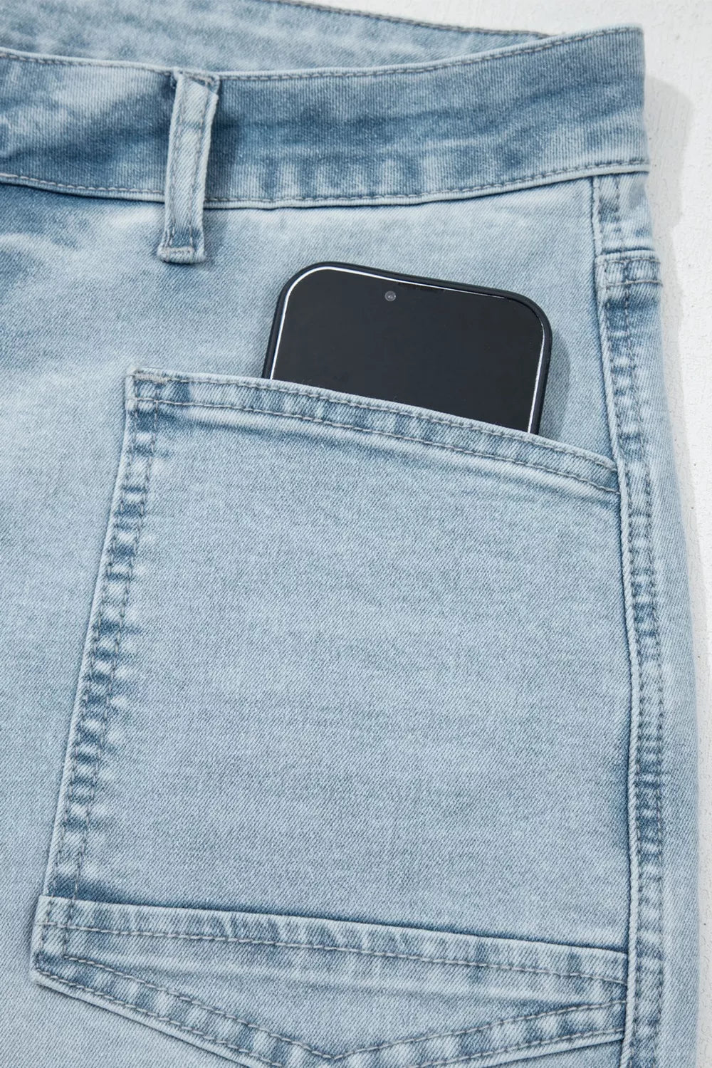 Utility pocket on light wash straight-leg jeans with a phone-sized front compartment